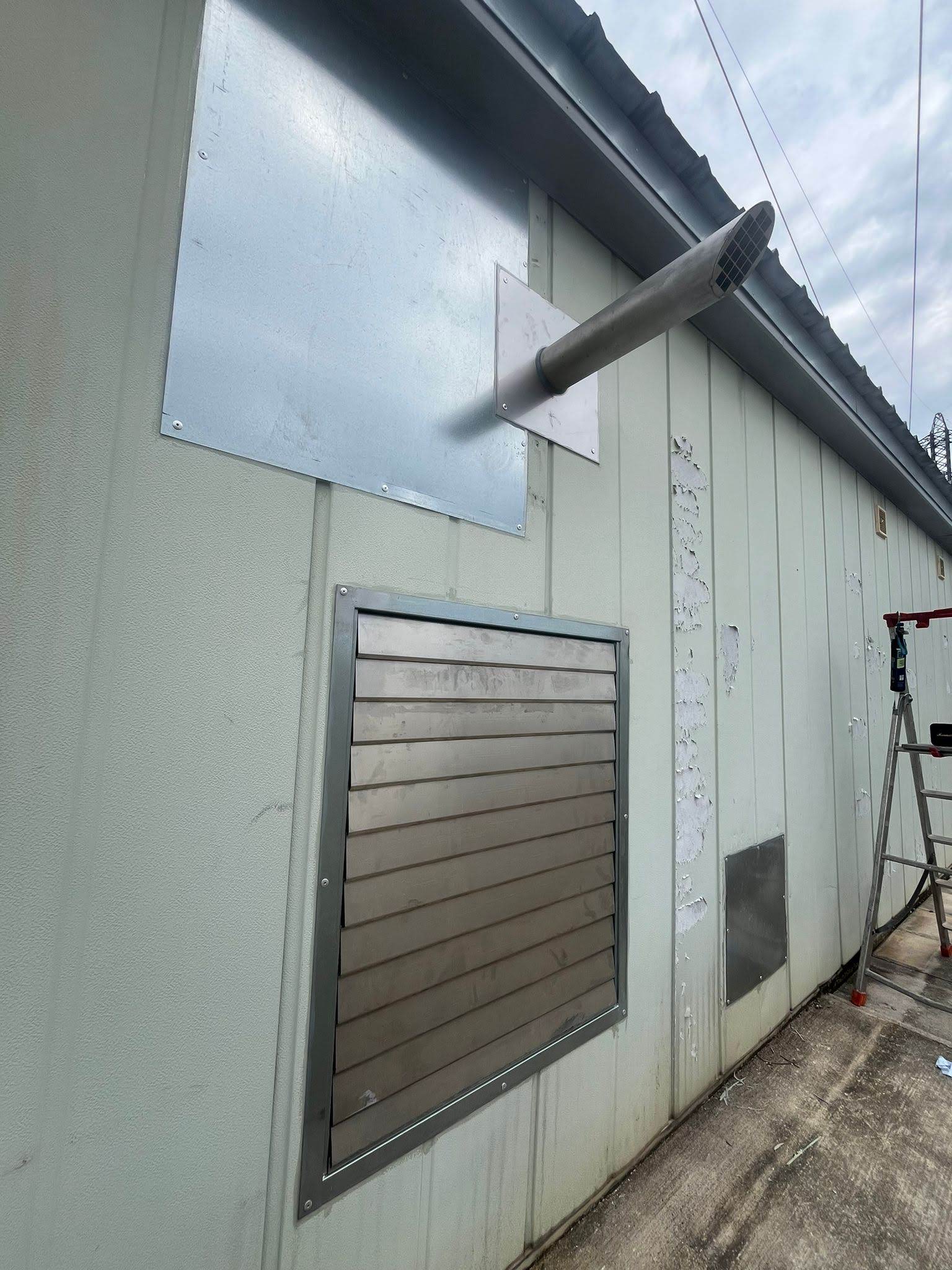 Sortie d'échappement coupe-sifflet et grille de ventilation en façade